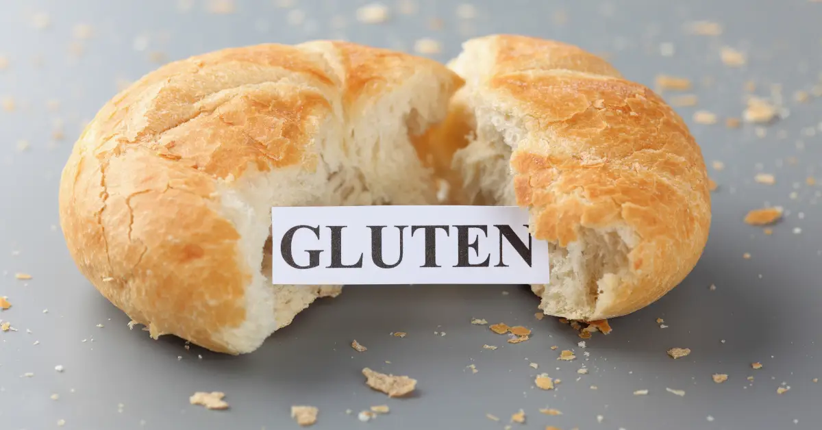 Freshly baked bread broken in half with a label that reads 'Gluten'