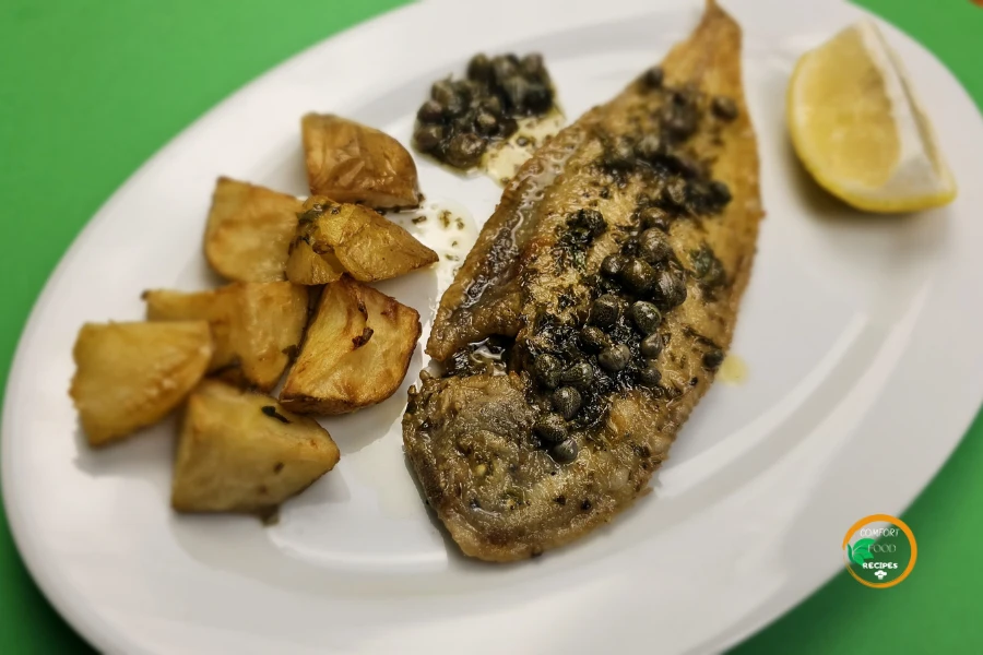 Sole Meunière with lemon and capers, a golden-brown fish fillet in a browned butter sauce, served with steamed potatoes and fresh parsley.